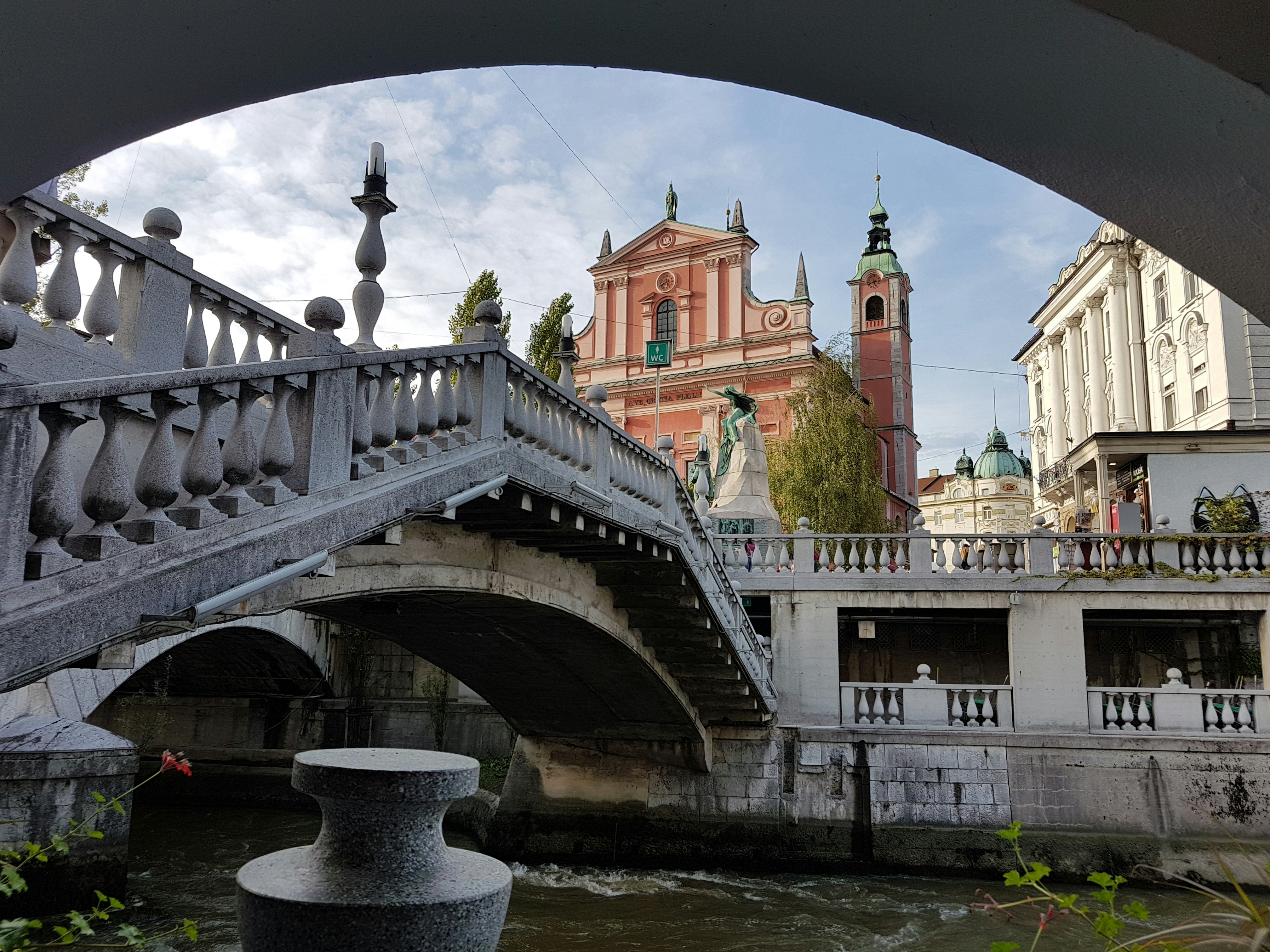 The white stone Triple Bridge fanning across the Ljubljanica river in Ljubljana